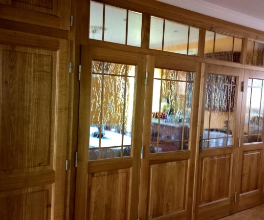 Vícekřídlá dveřní prosklená stěna, včetně vestavné skříně, dubový masiv, nástřik transparentní lak