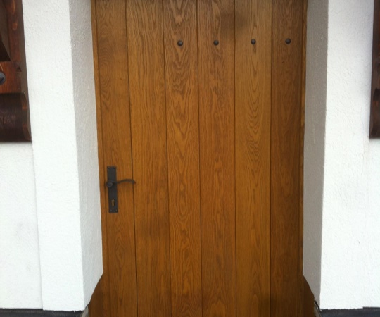 Vstupní dveře z dubového dřeva, tesané, drásané, nátěr lazurou.