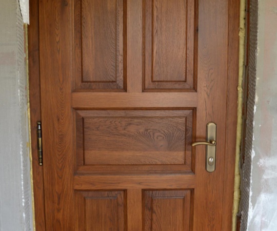 Dveře vstupní, kazetové, v rámové zárubni, dubové dřevo, nátěr lazurou.