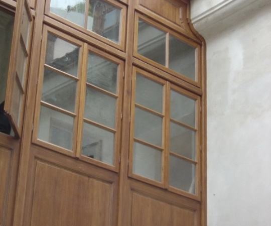 Pavlačová stěna, sestava oken a kazet, dubový masiv, nátěr lazurou.
