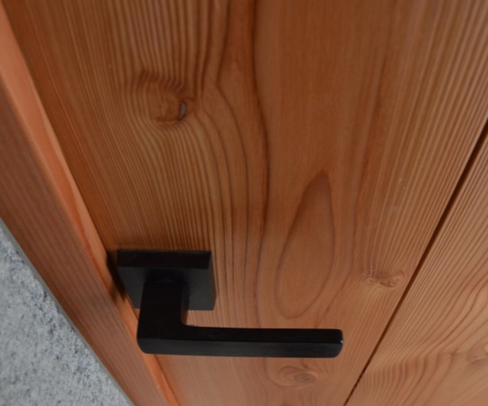 Detail kliky, vstupní dveře v moderním stylu, fošnové, s okénkem, černý kříž a hranatá klika, douglaska, drásané, nátěr olejem Osmo.