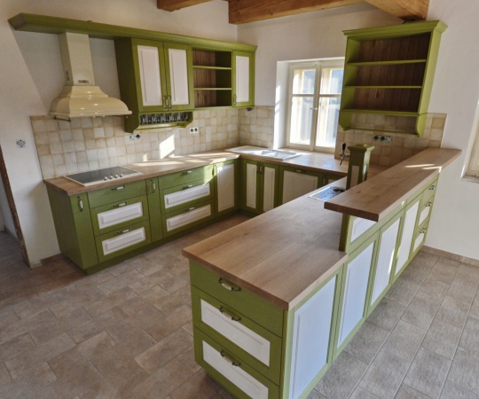 Kuchyň vyrobená na míru pro roubenku ctí poctivý venkovský styl. Pohledové části jsou ze smrkového kartáčovaného dřeva s jemným bílým a zeleným nátěrem, který nechává krásně vyniknout strukturu dřeva. Celek doplňuje masivní dubová pracovní deska, keramický dřez a vestavné retro spotřebiče značky SMEG. Pro chvíle domácí pohody u piva je kuchyň vybavena i výčepním zařízením se stojanem v barvách celé kuchyně. Vyrobeno pro www.podkrakonosovem.cz