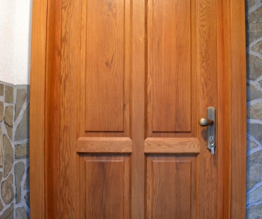 Dveře vstupní, kazetové, v rámové zárubni s obložkou, dubové dřevo, nátěr lazurou.