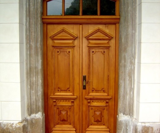 Replika historických dvoukřídlých, zdobených, smrkových dveří, rámová zárubeň s nadsvětlíkem, nátěr lazurou.