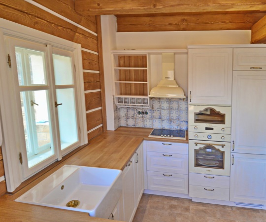 Kuchyň na míru pro roubenou stavbu v tradičním venkovském stylu. Pohledové korpusy ze smrkového drásaného dřeva s průsvitným bílým nátěrem doplňuje masivní dubová pracovní deska, keramický dřez a vestavné spotřebiče v retro stylu od firmy SMEG. Vyrobeno pro www.podkrakonosovem.czmy SMEG. Vyrobeno pro www.podkrakonosovem.cz