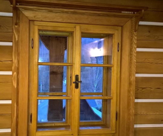 Špaletové okno v roubené stěně, včetně obložky s garnyží, smrk, drásaný, nátěr lazurou. 