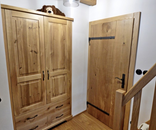Realizace do dětského pokoje, kde jsme dodávali dubovou vestavnou skříň na míru a vnitřní fošnové dveře. Vše je sjednocené materiálem, povrchově ošetřené olejem a doplněné o kované prvky.

