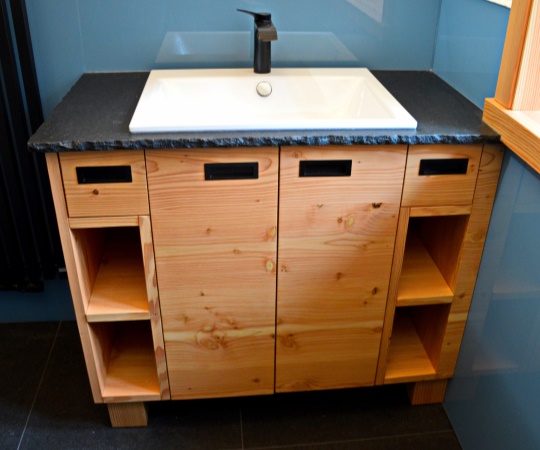 Moderní koupelnový stolek z douglaskového dřeva, drásaný, nátěr olejem. Dvířka a zásuvky, úchyty mušle černé. Vrchní deska žula NERO ASSOLUTO ZIMBABWE. 1020x850x520 (š*v*h)