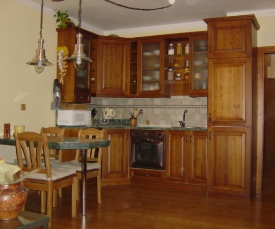 Kuchyň korpusy lamino, pohledové části jasanové dřevo, pracovní deska foliovaná dřevotříska, mořená, nástřik transparentní lak.