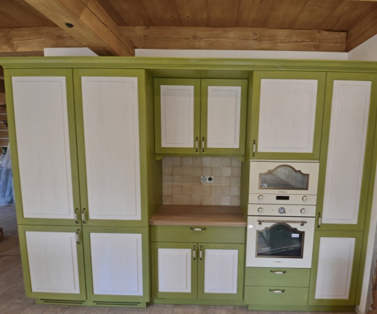 Kuchyň vyrobená na míru pro roubenku ctí poctivý venkovský styl. Pohledové části jsou ze smrkového kartáčovaného dřeva s jemným bílým a zeleným nátěrem, který nechává krásně vyniknout strukturu dřeva. Celek doplňuje masivní dubová pracovní deska, keramický dřez a vestavné retro spotřebiče značky SMEG. Pro chvíle domácí pohody u piva je kuchyň vybavena i výčepním zařízením se stojanem v barvách celé kuchyně. Vyrobeno pro www.podkrakonosovem.cz