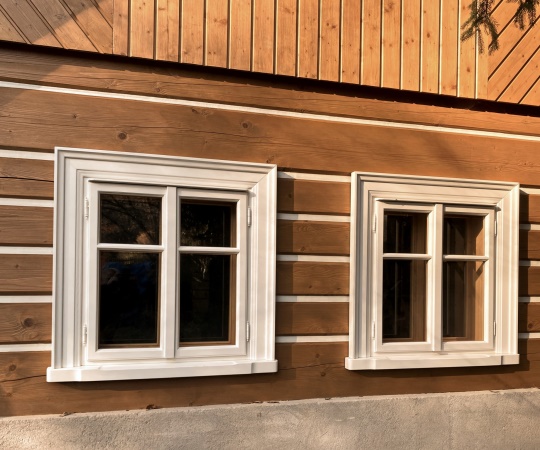 Špaletová (kastlová, deštěná) okna, dvoukřídlá, ze smrkového dřeva. Vnitřní strany jsou ošetřeny lazurou, vnější strana krycí barvou. Vnitřní i vnější okenní křídla mají jednoduché zasklení sklem float 4 mm. Okno je osazeno okenními rozvorami  Dáša v provedení bronz (mosaz patina).