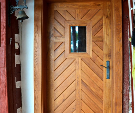 Dveře vstupní jednokřídlé, prkenné s okénkem, v rámové zárubni zakončené obložkou, dub, drásané, nátěr lazurou. 