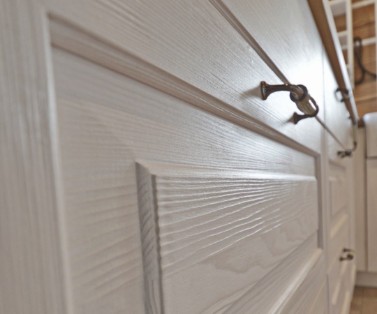 Detail, kuchyň na míru pro roubenou stavbu v tradičním venkovském stylu. Pohledové korpusy ze smrkového drásaného dřeva s průsvitným bílým nátěrem doplňuje masivní dubová pracovní deska, keramický dřez a vestavné spotřebiče v retro stylu od firmy SMEG. Vyrobeno pro www.podkrakonosovem.cz od firmy SMEG. Vyrobeno pro www.podkrakonosovem.cz