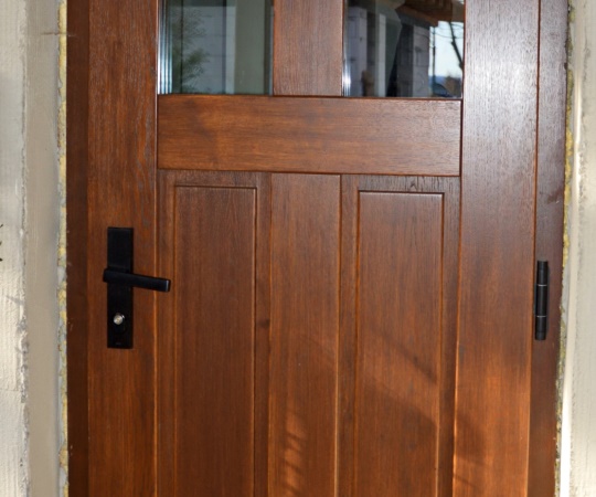 Dveře vstupní, kazetové, prosklené, v rámové zárubni, dubové dřevo, nátěr lazurou.