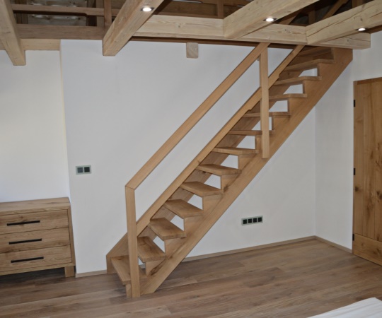 Polosedlové samonosné schody na hambalka, včetně zábradlí, fošnové vnitřní dveře v obložkové zárubni a třízasuvková komoda v moderním stylu, vše z dubového dřeva.