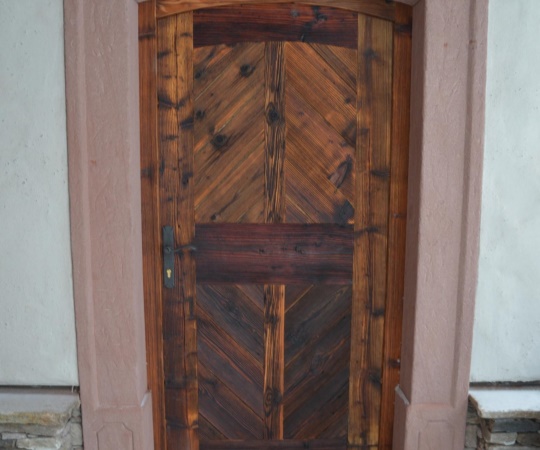 Dveře vstupní jednokřídlé, prkenné, v rámové zárubni do pískovce, ze starého sluncem a větrem ošlehaného dřeva, nátěr OSMO bezbarvý olej